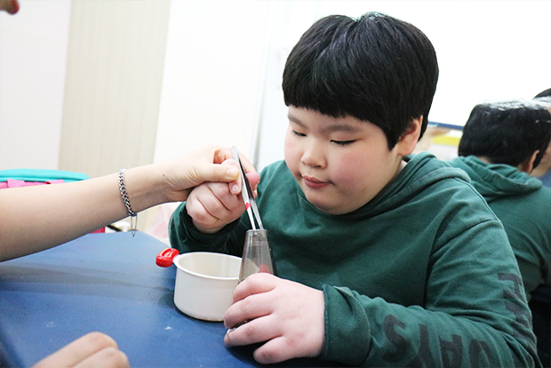 손을 움직여 소근육 발달을 돕는 작업치료 중인 지우