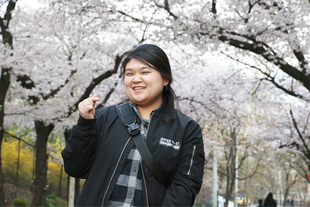 벚꽃이 흐드러진 회사 앞에서 활짝 웃고 있는 한혜인 기부자