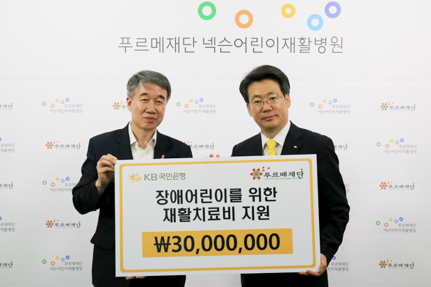 백경학 푸르메재단 상임이사에게 구승열 KB국민은행 상품본부장(오른쪽)이 장애어린이 재활치료비 3천만 원을 전달했다.