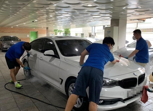지난 10일 오후 서울 종로구 신교동 푸르메재단 공영 주차장에서 '푸르메 오토 케어' 발달장애인 직원들이 세차하는 모습.