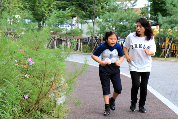 맞춤용 교정신발을 신고 걷기 연습을 하고 있는 장선우 어린이와 엄마 박미정 씨