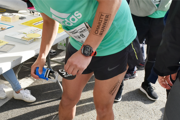 채러티 러너 도장을 찍고 미라클365 스티커를 붙이고 있는 참가자