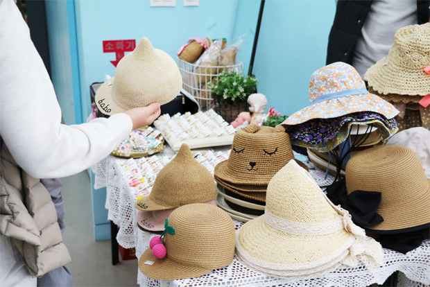 푸르메마켓에 나온 각양각색 모자를 살펴보고 있는 병원 이용자