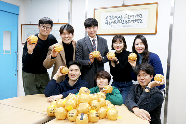 회수한 돼지저금통을 들고 활짝 웃고 있는 러닝크루 MRTK