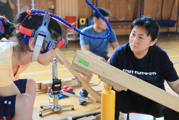 소정이가 목표지점을 향해 공을 굴릴 수 있게 기구의 위치를 조정하고 있는 엄마 김미진 씨