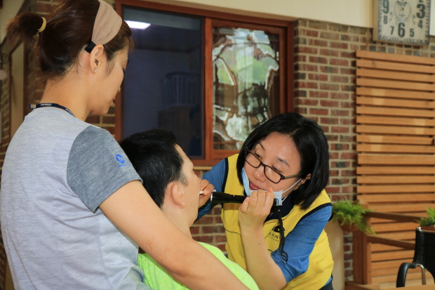 시설 이용자의 구강검진을 하고 있는 전현아 푸르메치과 원장