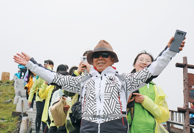 지난달 28일 백두산에 오른 엄홍길 대장과 아이들. 이날은 날씨가 흐려 천지의 모습을 제대로 보지 못했다. 푸르메재단 제공.