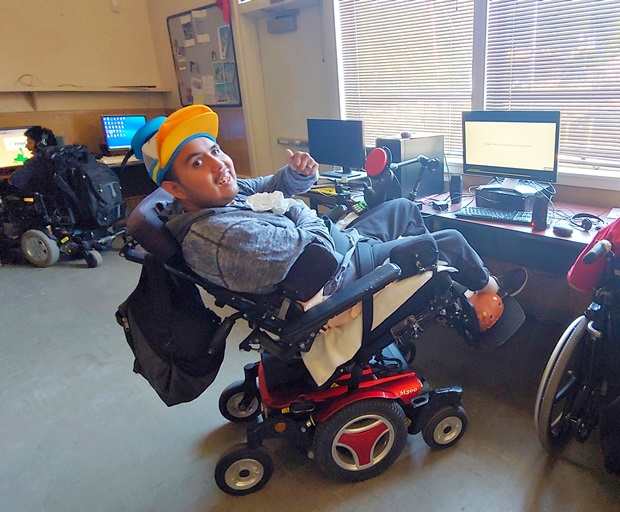 휠체어에서 손가락을 치켜든 장애인