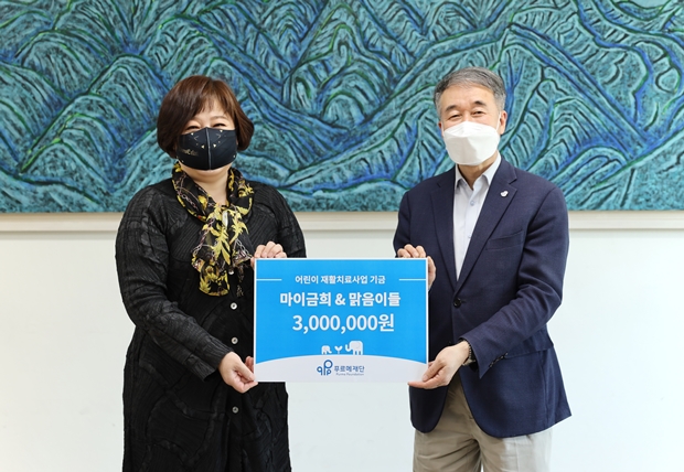 백경학 푸르메재단 상임이사에게 기부금을 전달하는 이금희 아나운서(왼쪽)