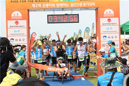 ▲ 지난 9월 서울 마포에서 열린 ‘은총이와 함께하는 철인3종 경기대회’에서 은총부자, 가수 션, 은총이 서포터즈가 결승점을 향해 달려오고 있다.