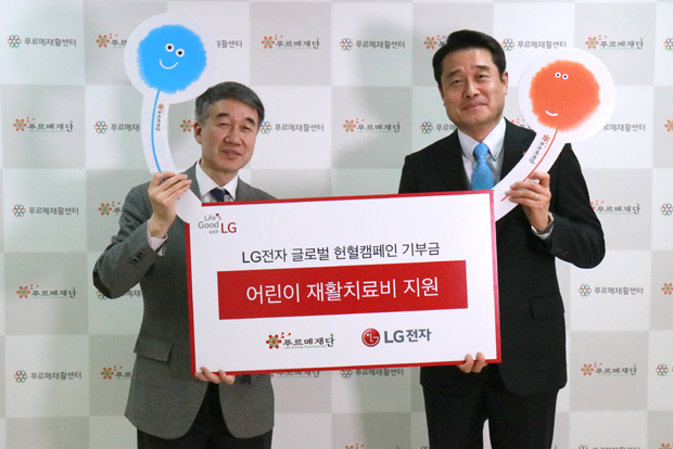  백경학 푸르메재단 상임이사(왼쪽)와 윤대식 LG전자 상무(오른쪽)가 장애어린이 재활치료비 기부금 전달식에서 기념촬영을 하고 있다.