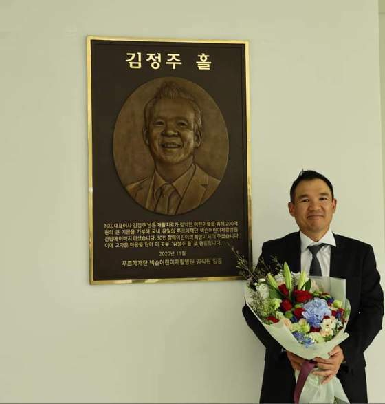 작년 4월 서울 상암동 푸르메재단 넥슨어린이재활병원 건립 5돌을 기념해 제막한 ‘김정주홀’ 앞에 선 고인. 사진 푸르메재단 제공