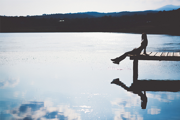 강가 쉼터에 걸터 앉아 있는 사람