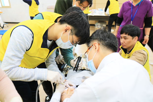 치과의사 옆에서 석션을 맡은 윤석헌 학생(왼쪽)