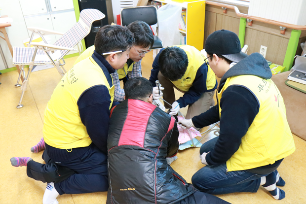 치료받고 있는 이용자의 몸을 고정시키고 있는 대원들