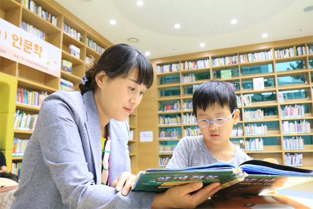 아들 두민이가 최고로 꼽는 장소인 어린이도서관에서 책을 읽고 있는 황혜진 씨