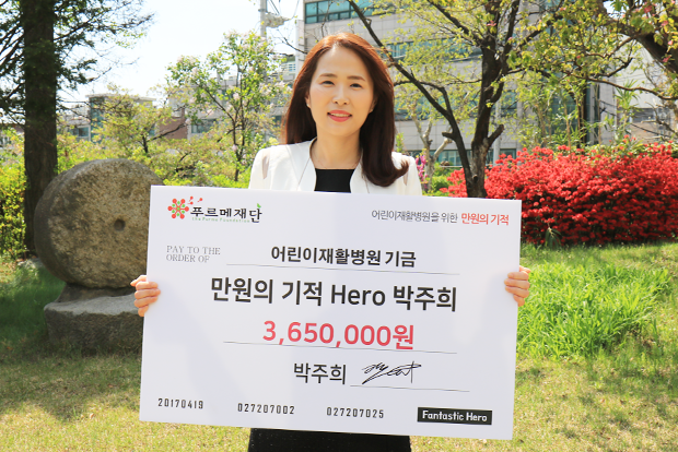 자신의 서명을 남긴 기부보드를 들고 기념사진을 촬영한 박주희 기부자.