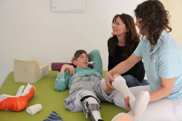 ▲ 물리치료사로부터 재활치료를 받고 있는 장애청소년(사진 오른쪽)과 곁을 지키는 어머니(가운데)의 모습. 치료사는 아이가 집에 돌아가서도 재활이 이어질 수 있도록 가족들에게 치료과정을 상세히 설명해 준다.