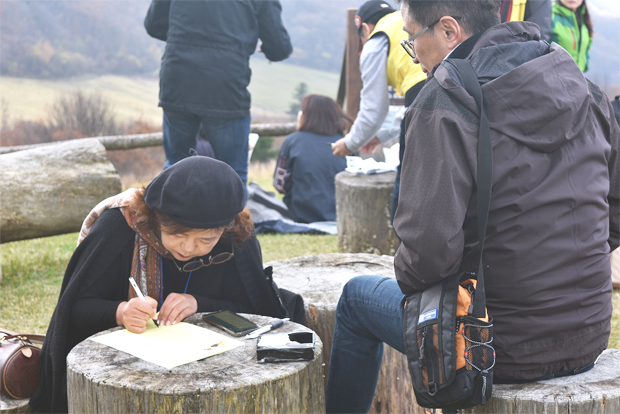 목장 전망대에 올라 시를 짓고 있는 한걸음의 사랑 회원들