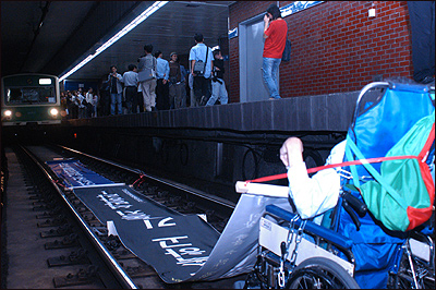 ▲ 2003년 9월 24일. 중증장애인이 지하철 2호선 시청역 선로를 점거하고 장애인 이동보장법률 제정을 촉구하는 모습. (사진 출처 : 에이블뉴스 http://abnews.kr/Lz8)