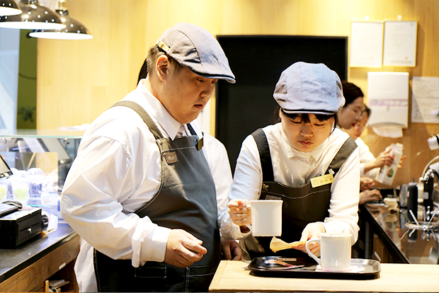 컵받침에 머그잔을 놓고 있는 서초본관점 바리스타들