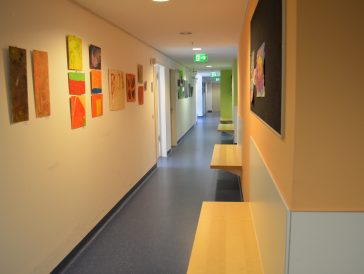 ▲ 미술작품이 걸어 밝게 꾸며진 병원동은 벽을 사이에 두고 보호자 대기석(상단)과 복도(하단)가 구분되어 있다.
