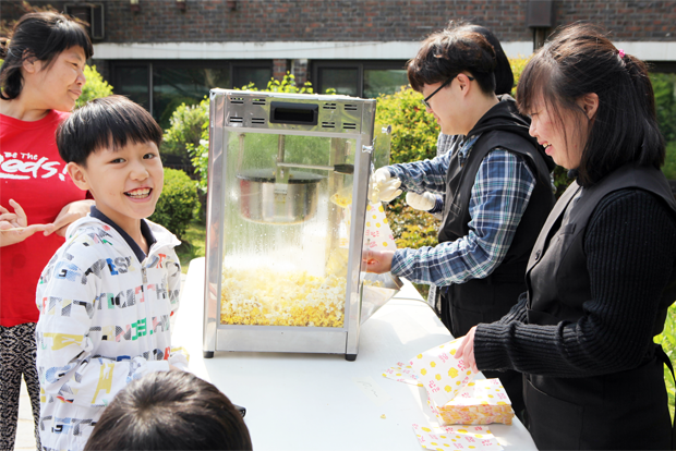직업적응 훈련생이 건넨 팝콘에 활짝 웃고 있는 어린이