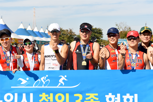 대회 완주 후 기념 메달을 걸고 기쁨을 나누고 있는 철인들