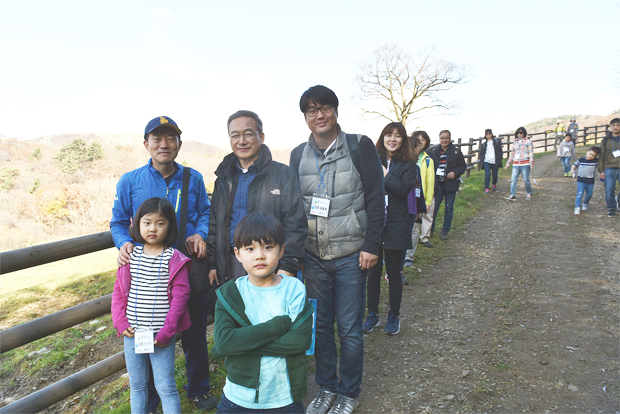 목장길을 걸으며 환하게 웃고 있는 정호승 시인과 한걸음의 사랑 회원들