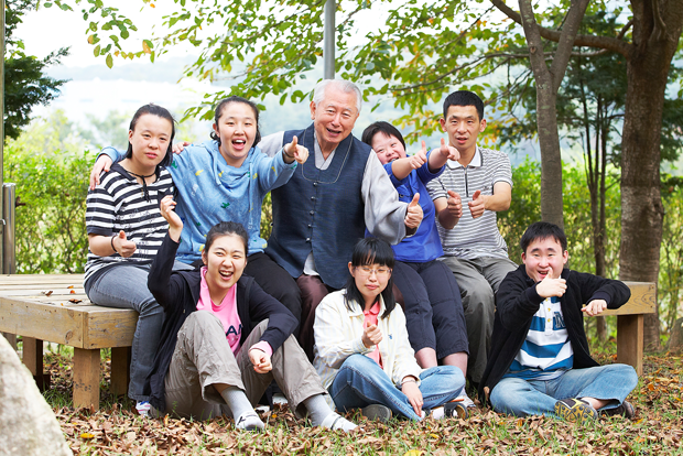 발달장애인들과 엄지를 치켜들며 웃고 있는 모습