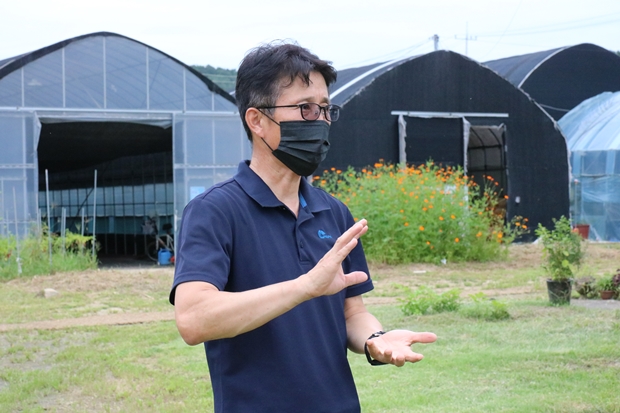 서울농원의 재배시설과 발달장애인 근로자들의 문화생활 시설을 소개해주는 장경언 원장. 서울농원에는 발달장애인들의 쉼과 사회능력 향상을 위한 그라운드 골프장이 마련되어있다.