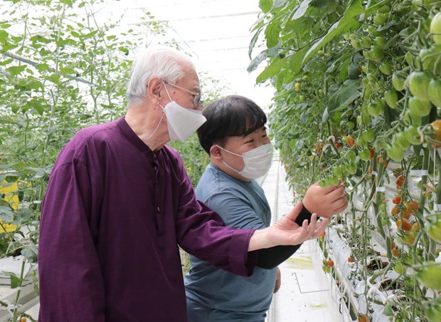 푸르메소셜팜 1기 직원 주호 씨(오른쪽)와 포즈를 취하고 있는 김성수 푸르메재단 명예이사장