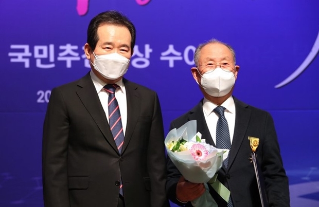 2021년 3월 3일, 지칠 줄 모르는 기부의 공로를 인정받아 국민훈장 석류장을 수상한 권오록 기부자. 시상자인 정세균 당시 국무총리와 함께.