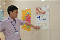 ▲ 효성인 모두가 함께 감사, 행복, 미소를 나눔으로써 GWT(Great Work Team)를 만들어나가는 ‘한마음활동’ 홍보포스터를 가리키는 김봉수 담당자