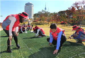 ▲ 지난 10월, LG유플러스 ‘사랑플러스’ 봉사단이 남산공원돌보미 활동의 일환으로 남산공원에서 잔디보호매트를 깔고있는 모습